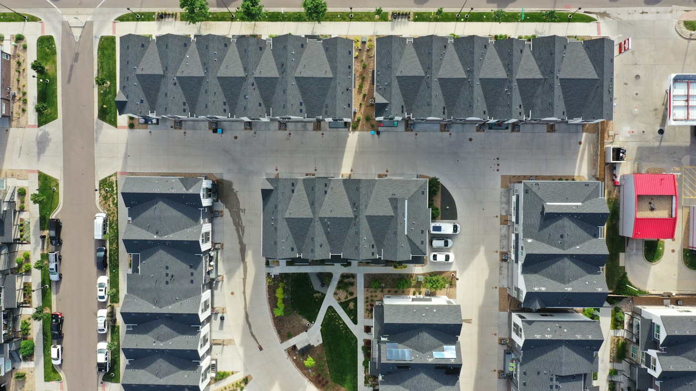 Aerial view of rows of townhomes with gray shingle roofs
