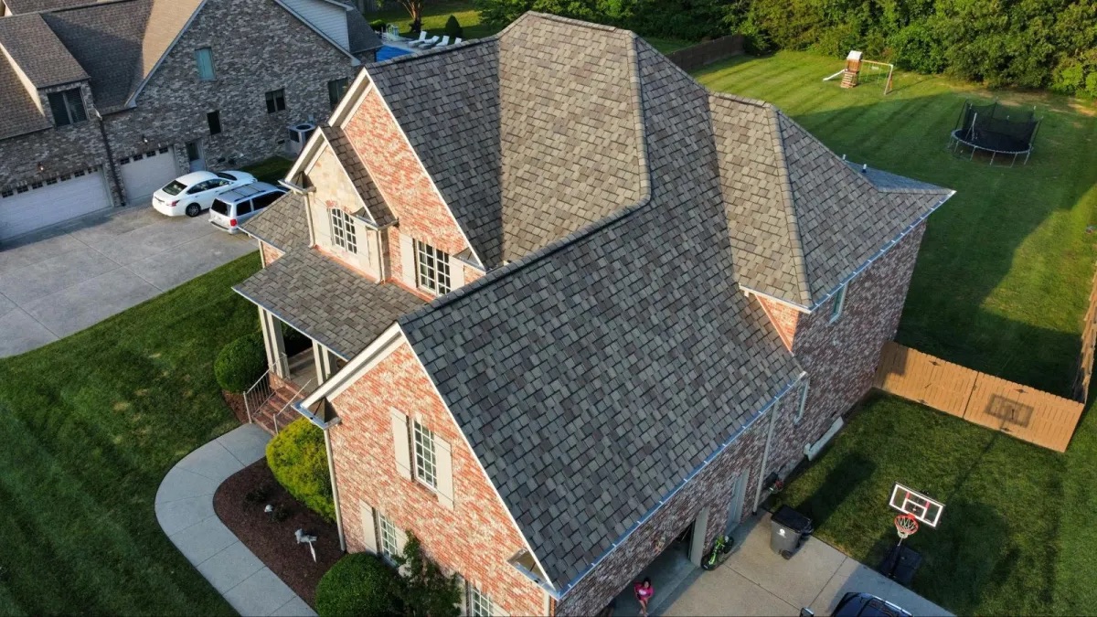 Aerial view of a brick house with a new architectural shingle roof